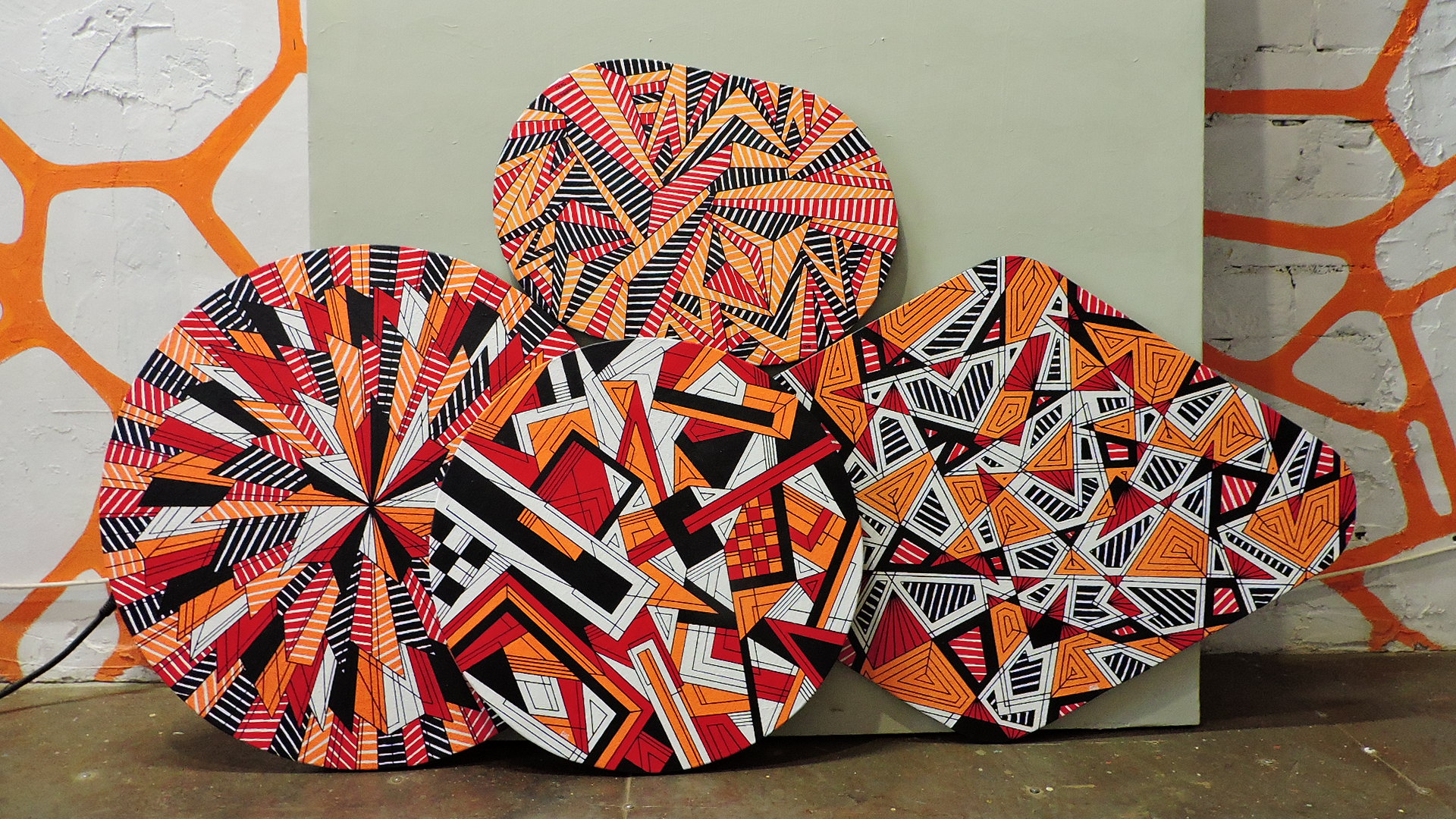 Four paintings of different geometric shapes, United by a common theme and color scheme